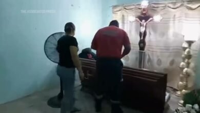 Womand declared dead in Ecuador bangs her coffin