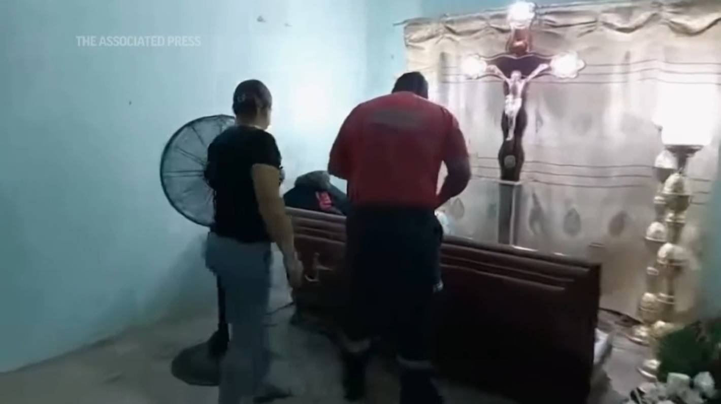Womand declared dead in Ecuador bangs her coffin